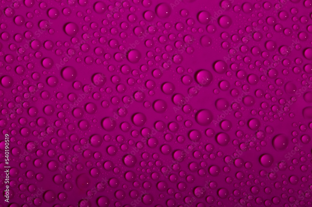 Water drops on glass as a background. Condensation on a cold drink. Red or pink background with drops texture. Water drops on glass as a background. Condensation on a cold drink. Red or pink background with drops texture.