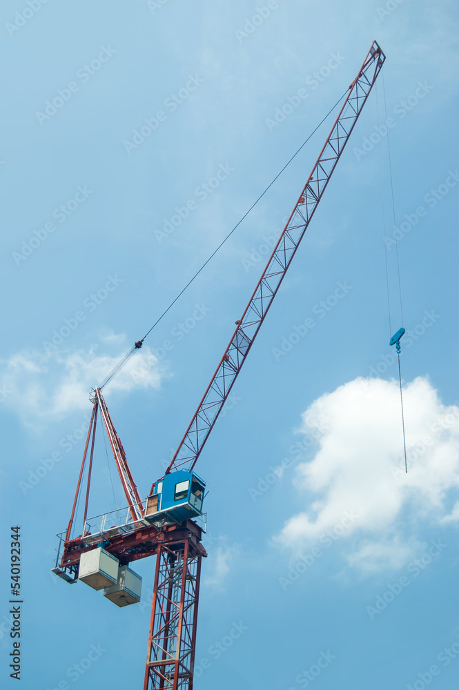 Tower crane at a construction site against the blue sky
