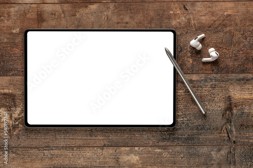 mockup digital tablet, stylus pen, earphone. Top view mock up digital tablet, stylus pen, earphone on wooden table