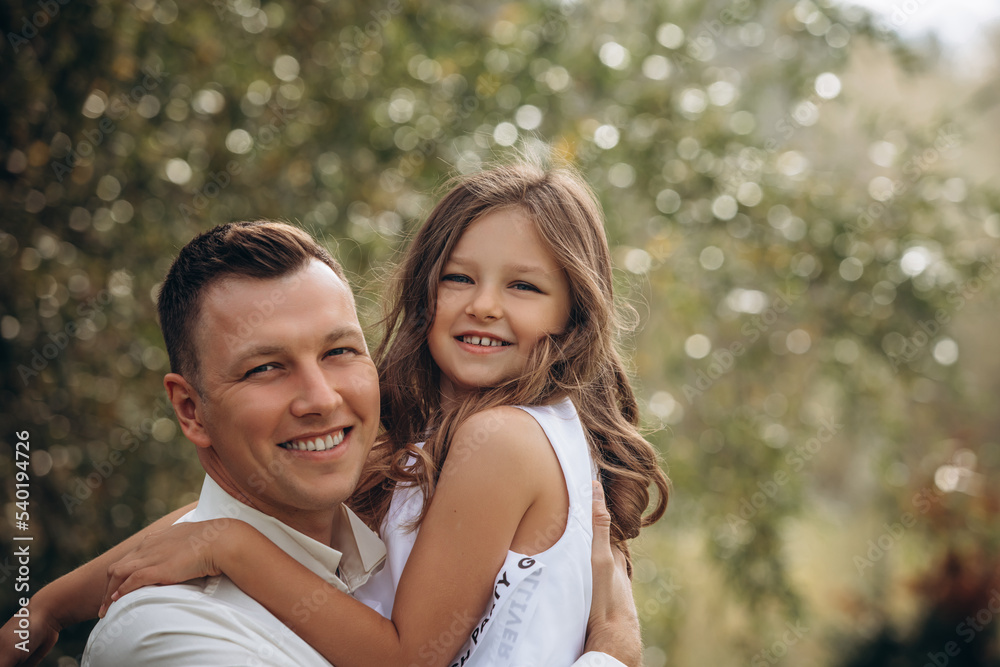 Family father and daughter are beautiful and happy together, in white clothes, in nature Family father and daughter are beautiful and happy together, in white clothes, in nature