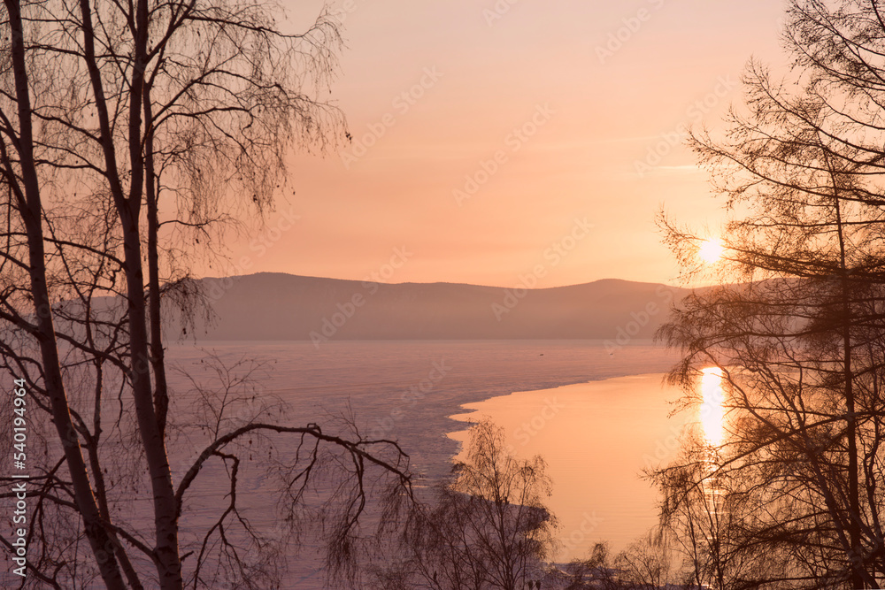 Beautiful sunset on frozen lake Baikal. Winter landscape.