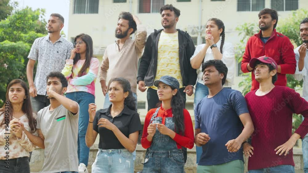 Serious tensed audience watching cricket sports match at stadiumby biting nails and praying god - concept of entertainment, championship and hopeful Serious tensed audience watching cricket sports match at stadiumby biting nails and praying god - concept of entertainment, championship and hopeful
