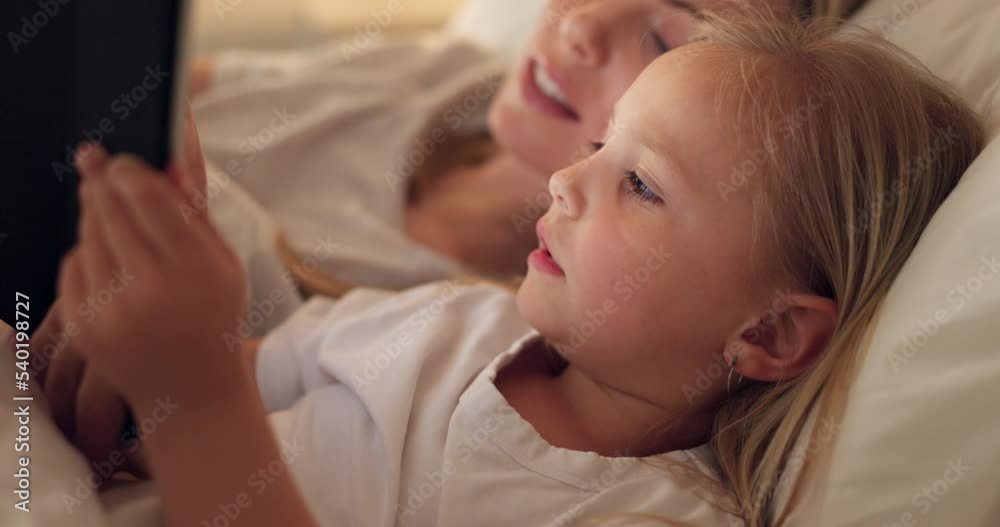 Tablet, mother and child on the internet in bed, streaming a movie or reading a book on the web at night. Education, learning and games on technology for a girl and her mom together in the bedroom Tablet, mother and child on the internet in bed, streaming a movie or reading a book on the web at night. Education, learning and games on technology for a girl and her mom together in the bedroom