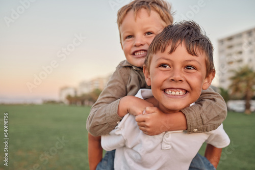 Fotografie, Obraz Happy, smile and portrait of brothers with piggyback ride playing in a park together on vacation