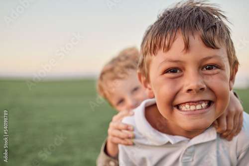 Friends, brothers and a smile, portrait in a field of happy boys having fun and playing in a park. Freedom, selfie and elementary schools children play and hug outside together on summer holiday.
