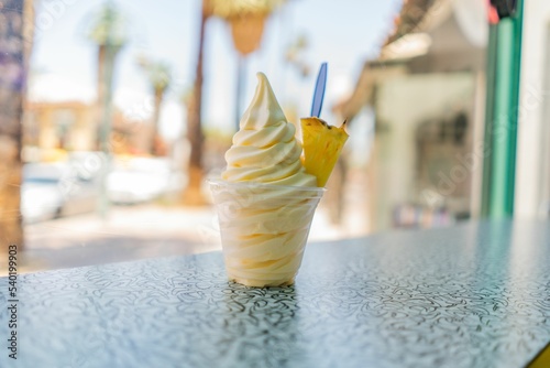 Fotografia, Obraz pineapple dole whip frozen yogurt ice-cream with a pineapple wedge on a countert