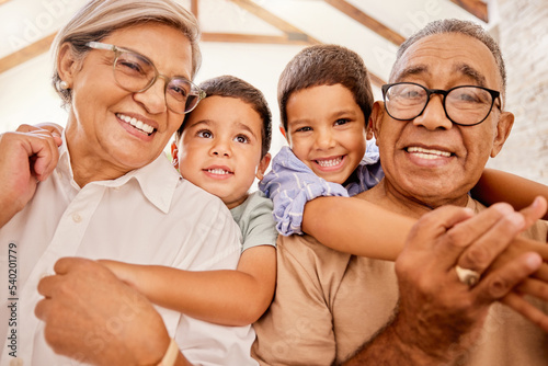 Grandparents  hug and children together at a house with happiness  family love and child care. Portrait of happy elderly people with kids smiling  bonding and spending quality time at a family home