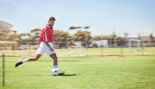 Football, running and soccer man with a ball doing a sport exercise, workout and training. Speed, action and young male athlete in a sports team uniform run a fitness cardio on a grass field
