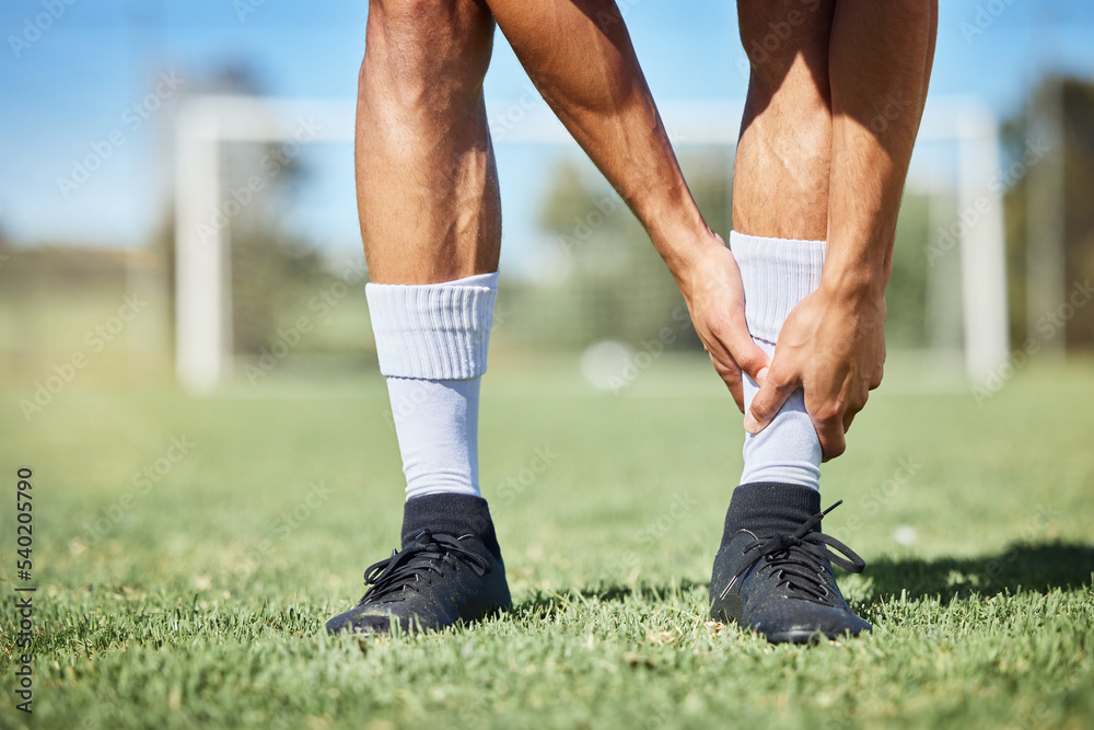 Sports, soccer and ankle injury on grass with self assessment of physical pain at athlete game. Hurt, injured and joint discomfort of football man on field checking painful leg at competition. Sports, soccer and ankle injury on grass with self assessment of physical pain at athlete game. Hurt, injured and joint discomfort of football man on field checking painful leg at competition.