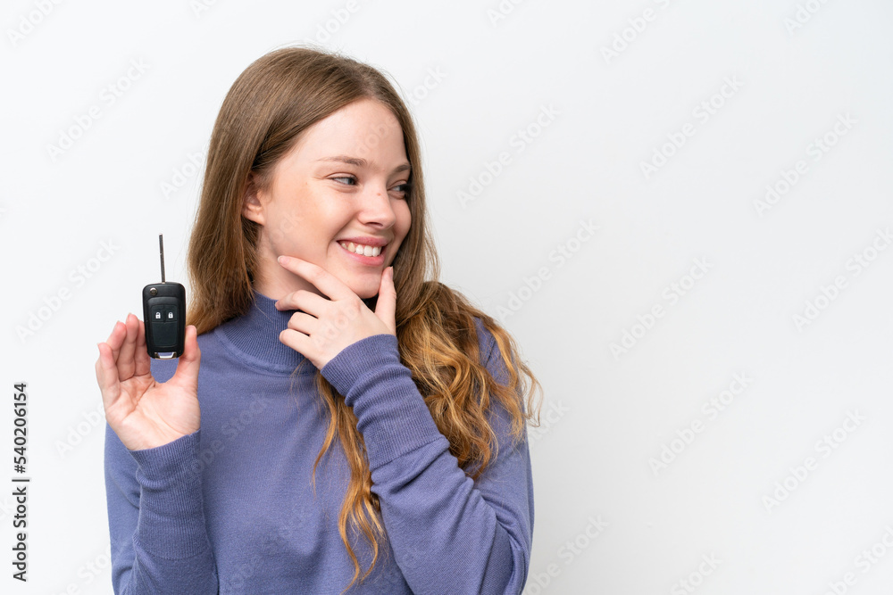 Young caucasian woman holding car keys isolated on white background thinking an idea and looking side Young caucasian woman holding car keys isolated on white background thinking an idea and looking side