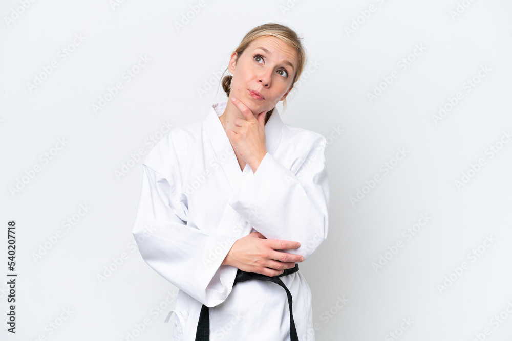 Young caucasian woman doing karate isolated on white background and looking up Young caucasian woman doing karate isolated on white background and looking up