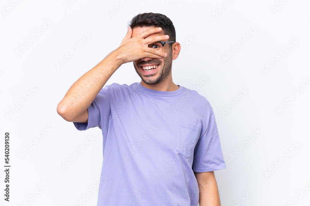 Young caucasian man isolated on white background covering eyes by hands and smiling Young caucasian man isolated on white background covering eyes by hands and smiling