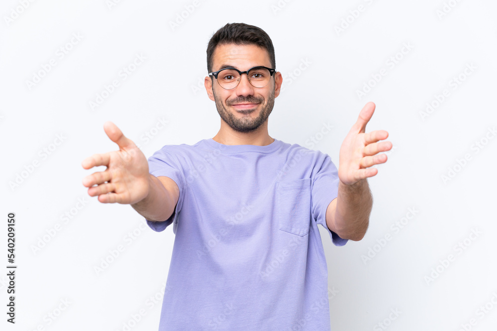 Young caucasian man isolated on white background presenting and inviting to come with hand Young caucasian man isolated on white background presenting and inviting to come with hand