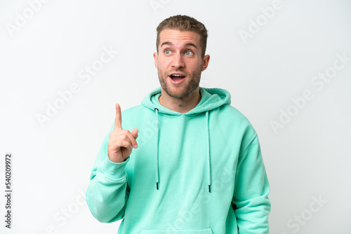 Young handsome caucasian man isolated on white background thinking an idea pointing the finger up © luismolinero