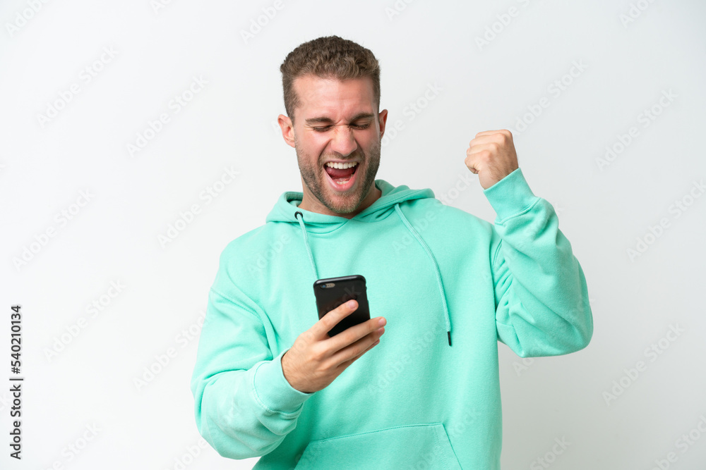 Young handsome caucasian man isolated on white background with phone in victory position Young handsome caucasian man isolated on white background with phone in victory position