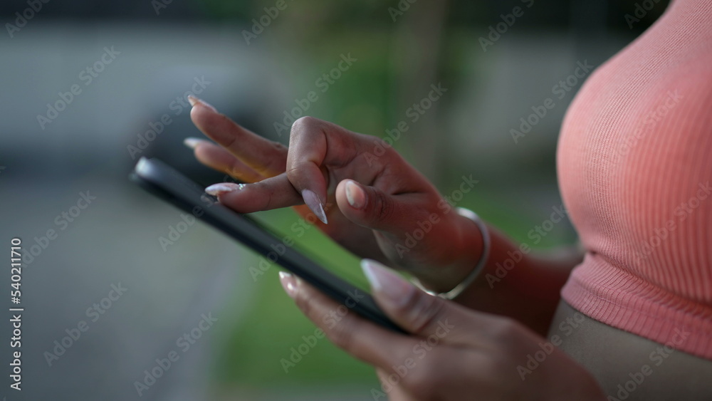 Closeup female hands holding tablet device touching screen with finger outdoors Closeup female hands holding tablet device touching screen with finger outdoors