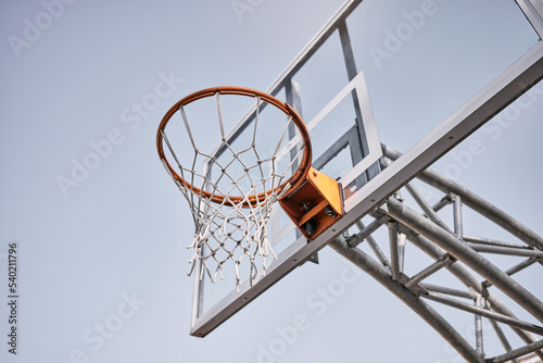 Basketball court, fabric or goals net for match, competition game or fitness in low angle on blue sky in New York. Basketball hoop, texture or sports exercise for training, wellness or winner workout © Beaunitta V W/peopleimages.com