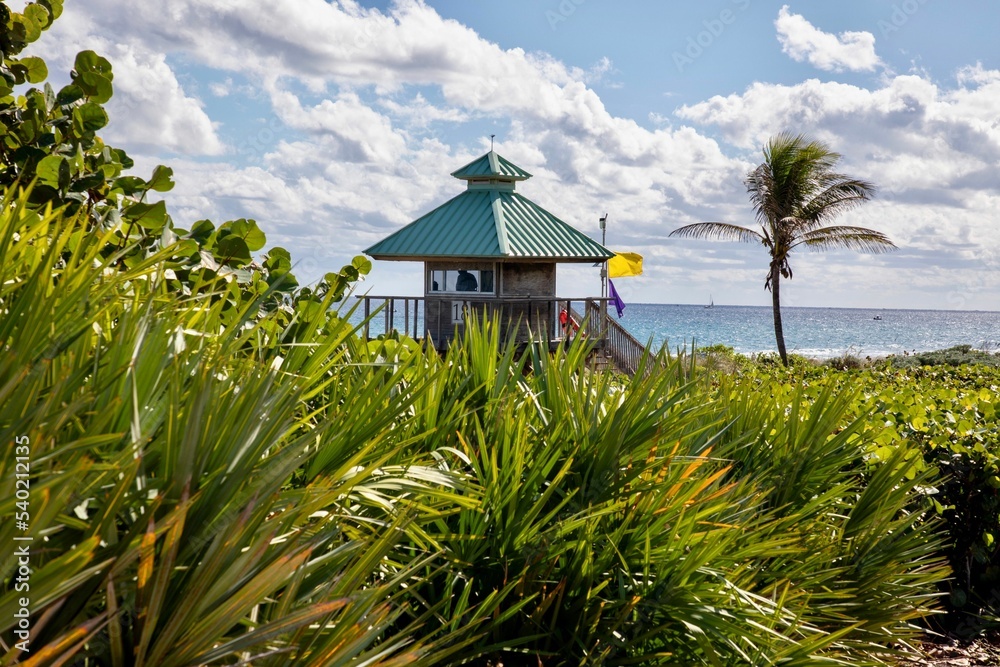 Naklejka premium Wooden lifeguard station on Boca Raton beach with warning flags, Florida, USA
