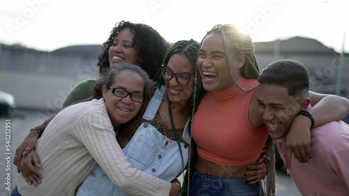 A black family embrace. Group of South American hispanic people hugging each other outdoors. Portrait of happy friends embracing. Friendship concept