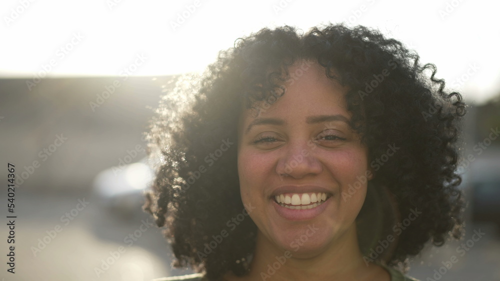 One happy black woman smiling at camera standing outdoor. Portrait face closeup of African American female person One happy black woman smiling at camera standing outdoor. Portrait face closeup of African American female person