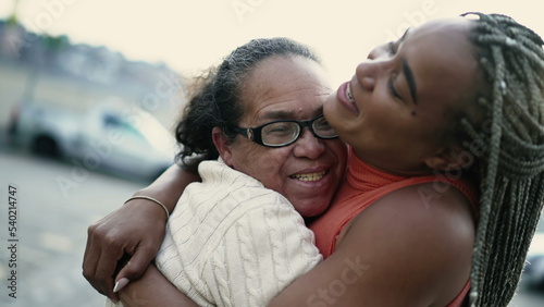 Joyful older grandmother and adult daughter hugging outside. South American Brazilian people family love and affection