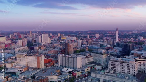aerial view drone of birmingham city downtown at dawn ,flying backwards rising up colorful sunrise uk england photo