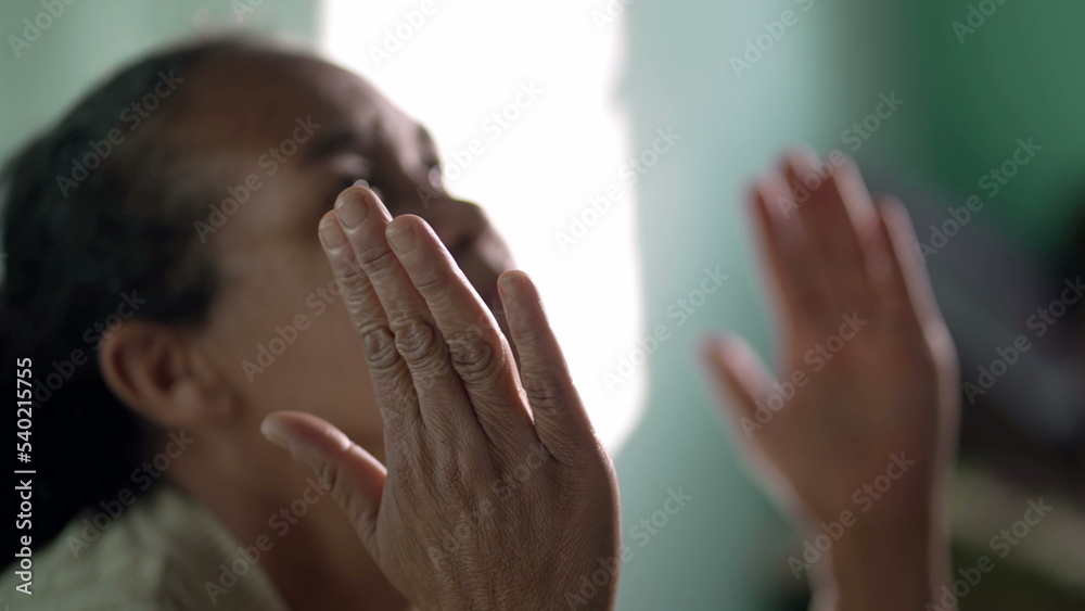 Older woman praying to God at home. One hispanic senior lady in prayer closeup face. Hispanic South American person