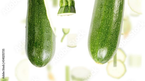 Zucchini vegetable pieces, slices and leaves falling down isolated on white. Seamless looping. High quality 4k video.