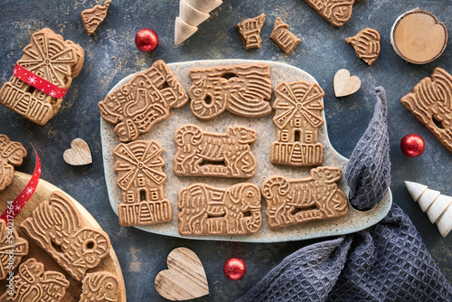 Speculoos or Spekulatius, Christmas biscuits, chocolate balls and towel on dark textured background. Traditional German sweets, cookies for Xmas on ceramic cutting board. photo