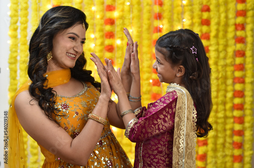Happy young woman and daughter celebrating diwali holding gift boxes 