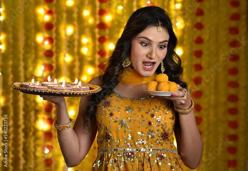 Happy young woman celebrating diwali 