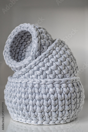 close-up of a beautiful cozy gray crochet baskets  organizers of various small things  storage. a nice hobby in the winter evenings. Sustainable  organic lifestyle advertising. One inside the other