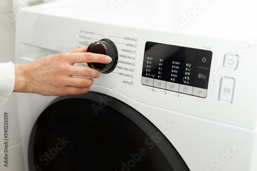 Close-up of a woman's hand adjusting a washing machine