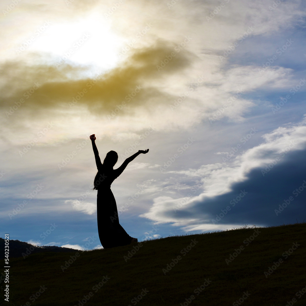 Silhouette of happy woman against the sky 