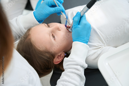 Experienced pedodontist treating dental caries in pre-teen child