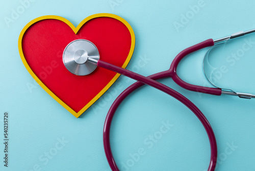 Red heart and stethoscope lies on a blue background