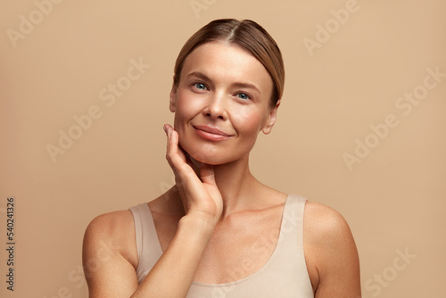 Smiling Woman Touching Face. Waist up Portrait of Attractive Woman Touching her Skin and Smiling. Woman Appearance and skin Care Concept 