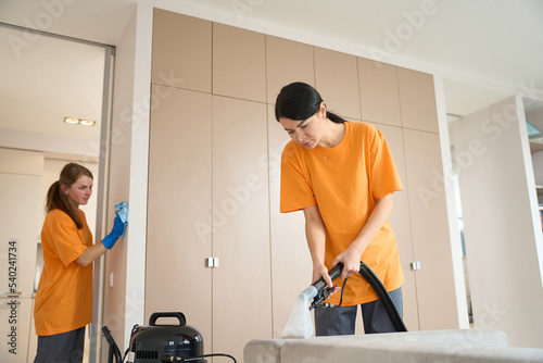 Women from cleaning company working in the house