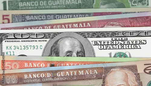 Guatemalan quetzal and US 100 bill. Close up Guatemalan banknotes and US banknotes. 