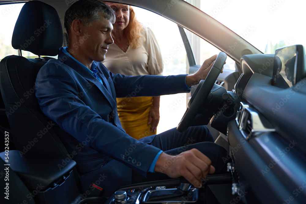 Man consulting with wife about buying a car Man consulting with wife about buying a car