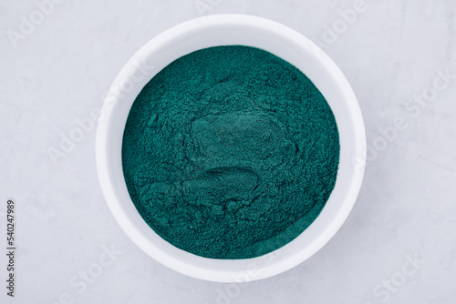 Spirulina. Green algae powder chlorella, spirulina in bowl on gray stone background