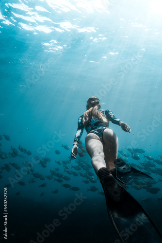 underwater girl who dive in deep ocean with fish