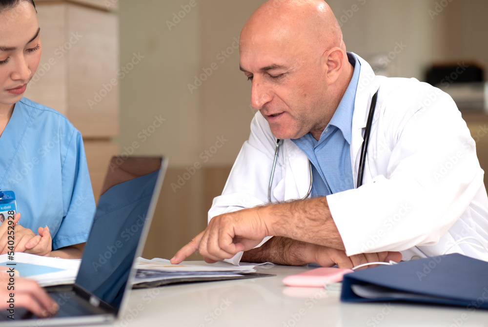 Male doctor meeting with medical teamwork woman in hospital. Professional healthcare expertise talking, explaining discussion with female nurse working in medical clinic. Health care business concept Male doctor meeting with medical teamwork woman in hospital. Professional healthcare expertise talking, explaining discussion with female nurse working in medical clinic. Health care business concept