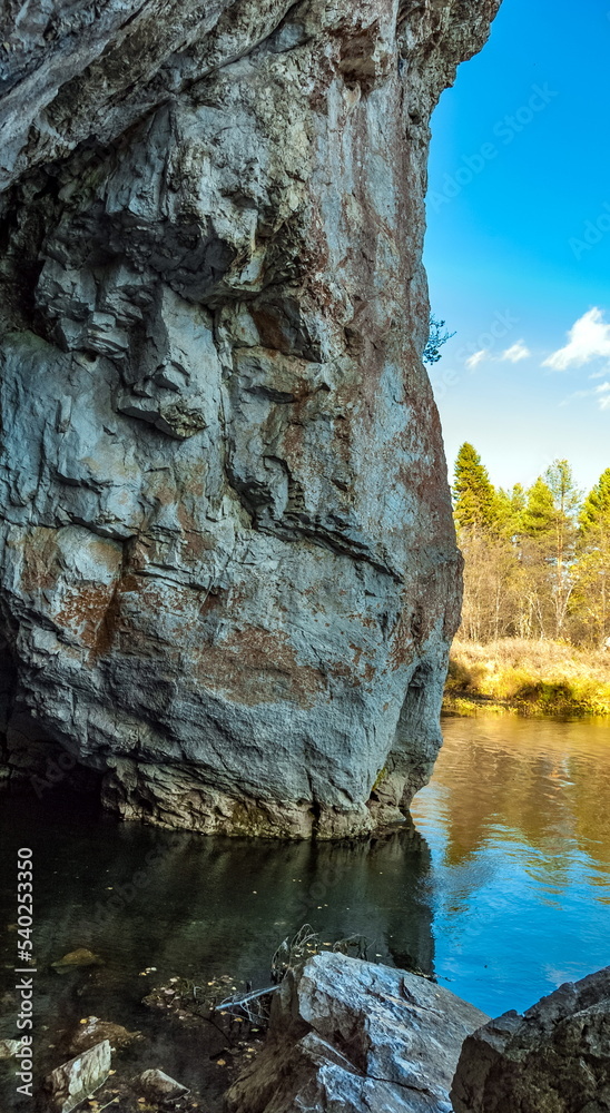 Fototapeta premium Autumn landscape with river, rock, trees and blue sky