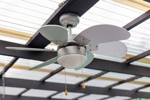 grey ceiling fan with pull cords under clear roof