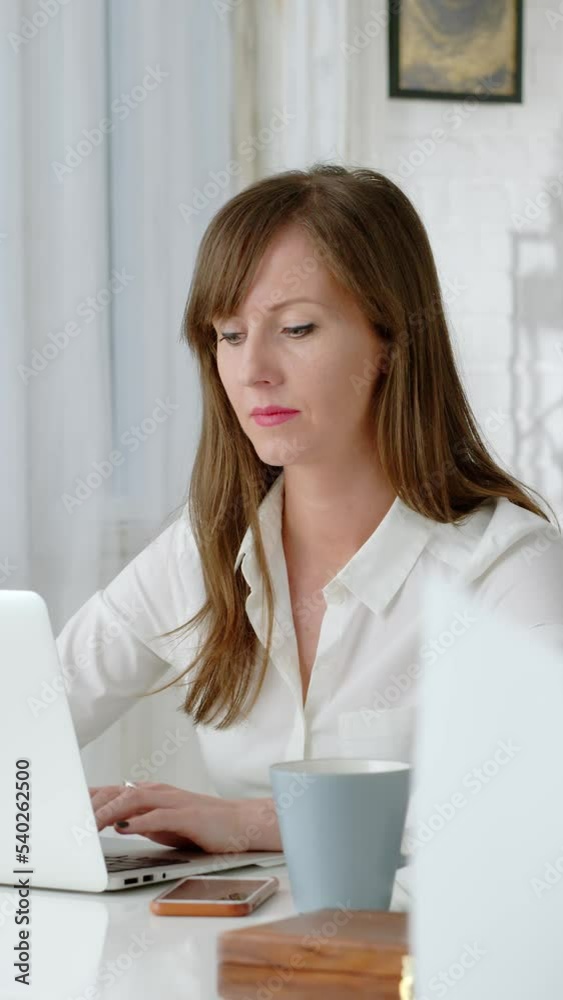 Young business woman working at desk with laptop computer in home office. Young business woman working at desk with laptop computer in home office.