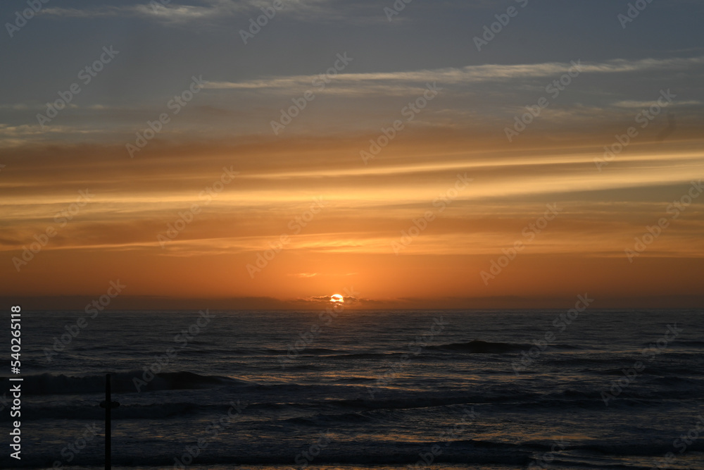 The sun rises over the ocean.