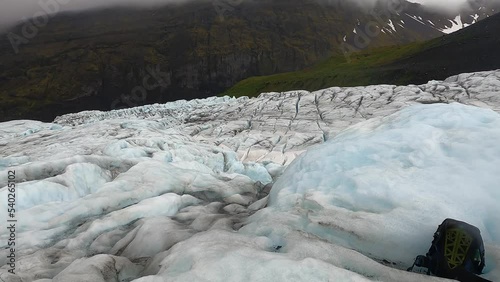 Skaftafell Glacier view, part of Vatnajökull National Park, Iceland. Blue glacier ice with cracks and crevasses, rainy and foggy weather. photo