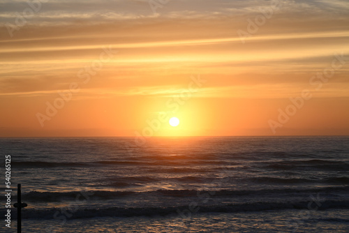 The sun rises over the ocean. © Jon