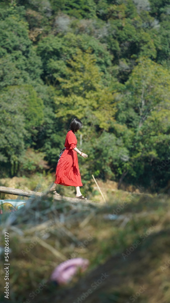 The young  Chinese couple walking on the country road with the warm sunlight